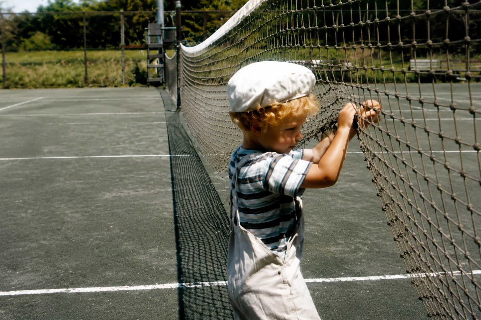 Un jeune enfant sur un terrain de tennis
